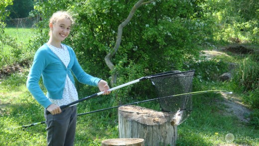 Mädchen mit Kescher und Forelle